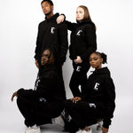 Models wearing black sweatsuits. The sweatsuits are imprinted with the E's Element logo in white. The models are also wearing matching white sneakers.E's Element Essential Smoky Black Sweatsuit Set by E's Element.