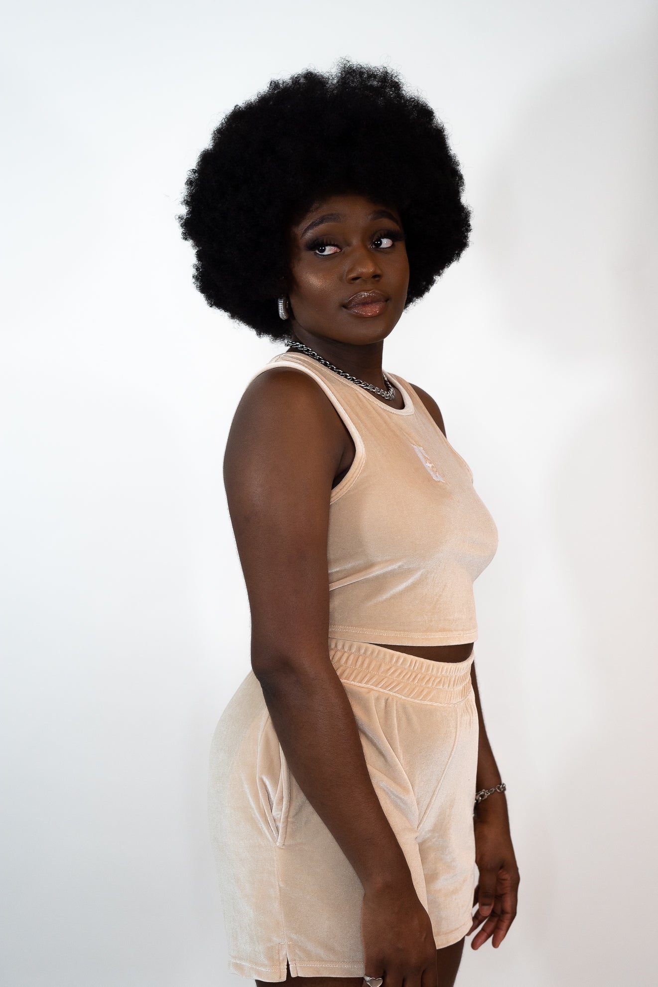 Model wearing beige tank top and shorts. The tank top has E's Element imprinted in white in the middle. Ella Champagne Velvet Set by E's Element.