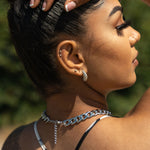Model wearing 18k silver croissant shaped earrings. She is also wearing silver chain bracelet and necklaces. Thick Croissant Stud Earrings - E's Element.
