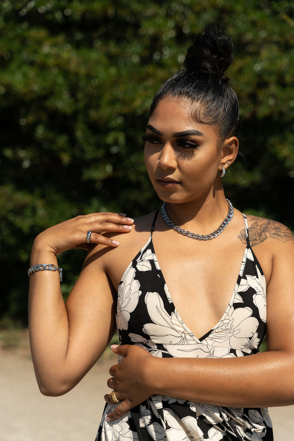 Model in a black and white dress wearing stainless steel chain necklace and bracelet. She is also wearing stainless steel rings and earrings.  The Emmanuela Set in Steel by E's Element.