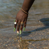 Woman's hands dipping in water wearing E's Element 4 piece set.
