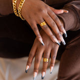 Model wearing dark brown sweat suit. On her ring fingers are 18k gold molten rings. Ella Lava Ring 2.0 by E's Element.