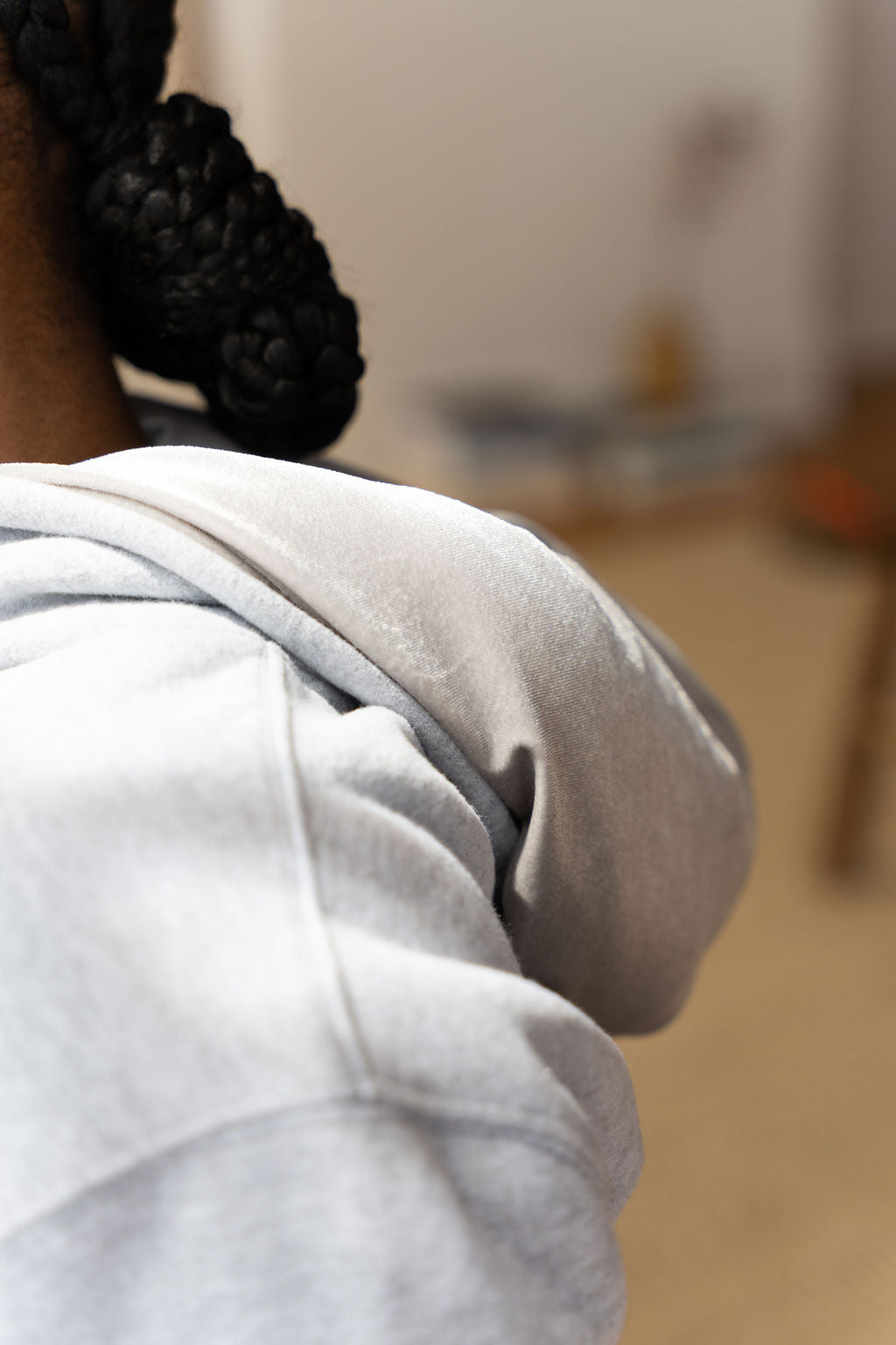 Woman wearing a light grey hoodie. The hoodie is a part of the Essential Light Grey Sweatsuit Set by E's Element.