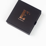 Cap of a box in black. The cap has the E's Element logo imprinted in gold. Gift Box (Add-On) by E's Element.