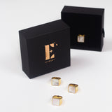 18k gold ring. The ring has a shell attached. Three of the rings are placed in front of a black container with the E's Element logo in gold. Behind the container is an open container with the ring placed inside. Shell Signet Ring by E's Element.