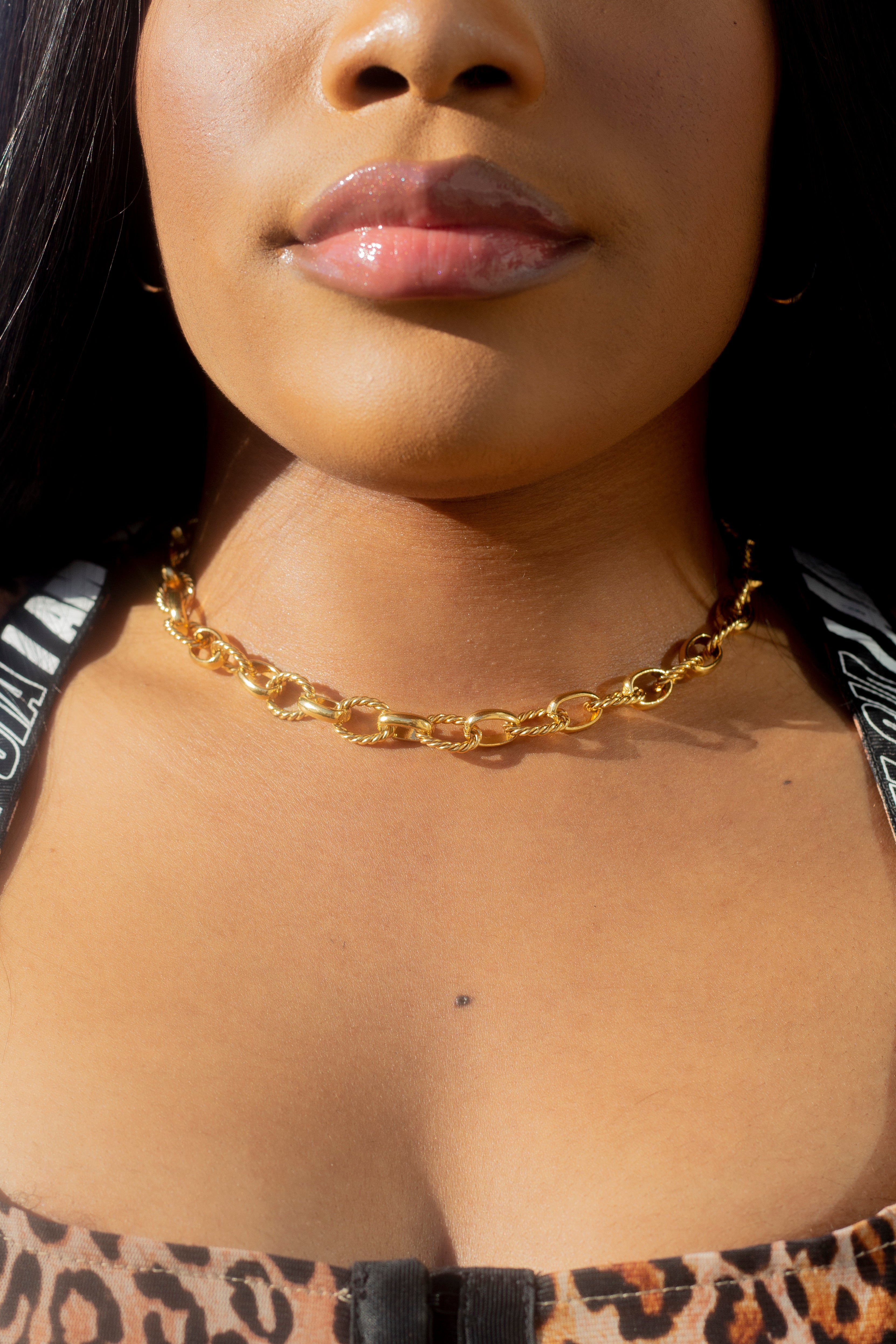 Model in a leopard top wearing 18k gold chain necklace with a rope pattern. Rope Link Signature Chain by E's Element.