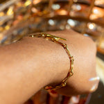 Model wearing 18k gold chain bracelet. Hollow Signature Chain Bracelet by E's Element by Emmanuela Okon.