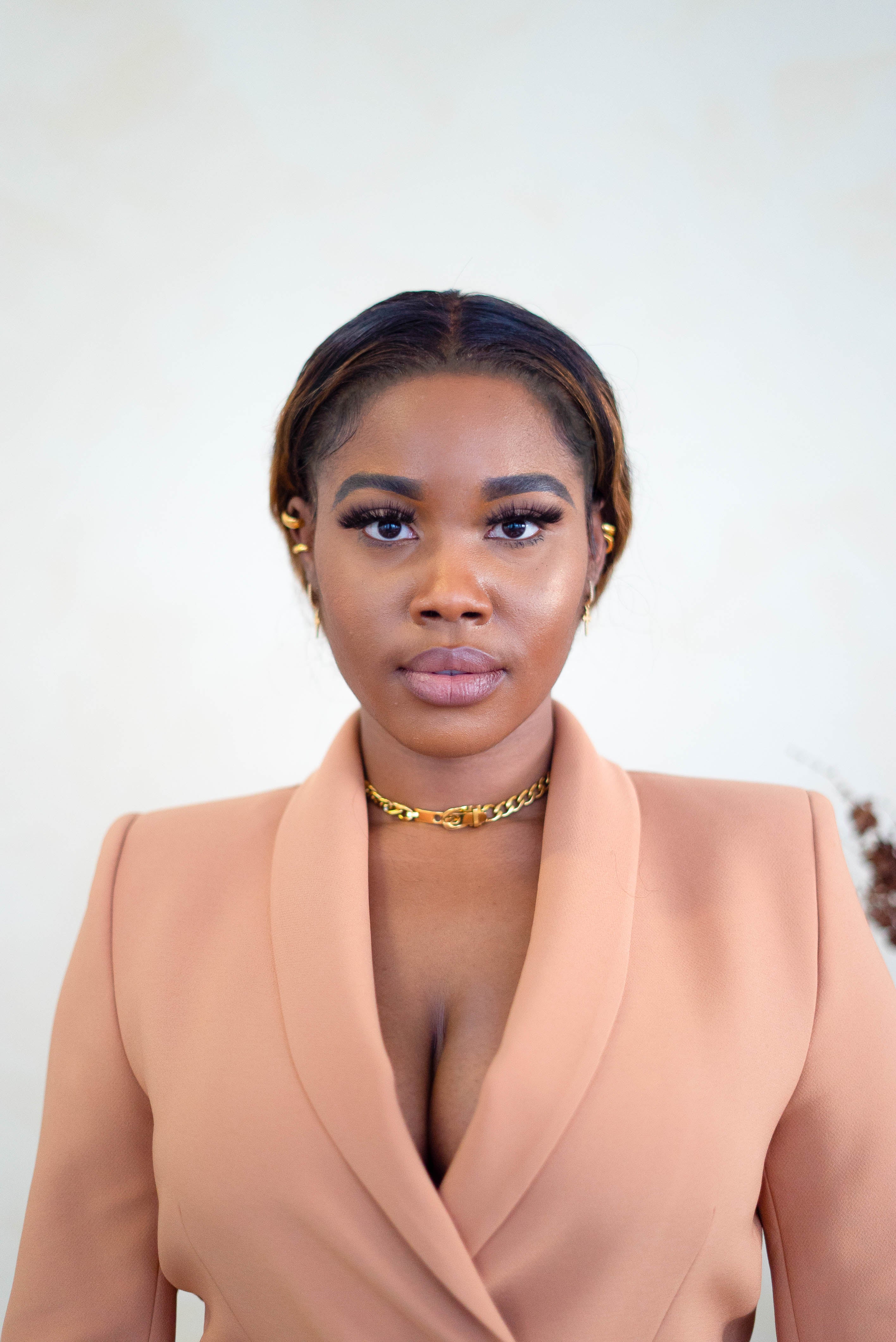 Model in a pink suit wearing 18k gold stainless steel buckle choker. Ella Buckle Choker by E's Element.