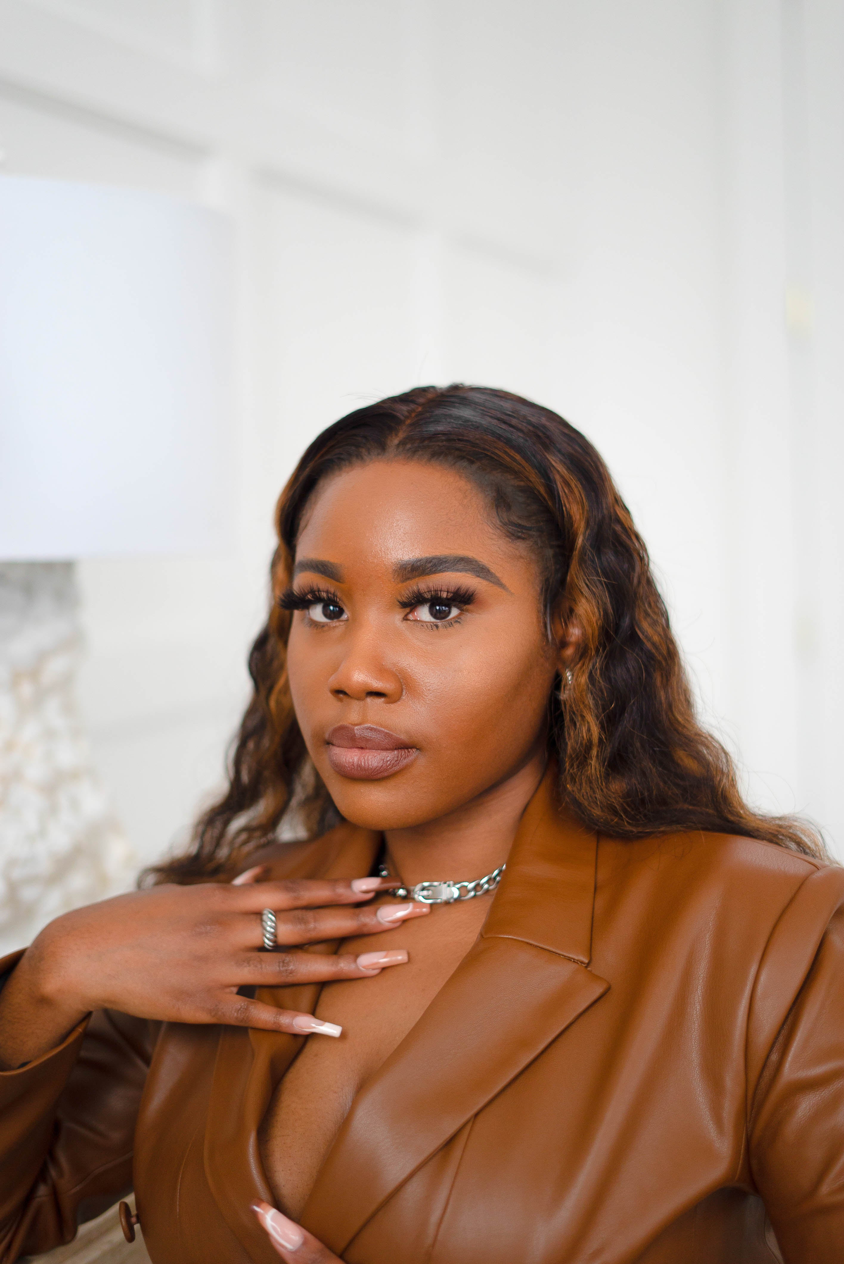 Model in a brown leather jacket wearing 18k silver croissant ring. She is also wearing a silver chain necklace. Thick Croissant Rings by E's Element.