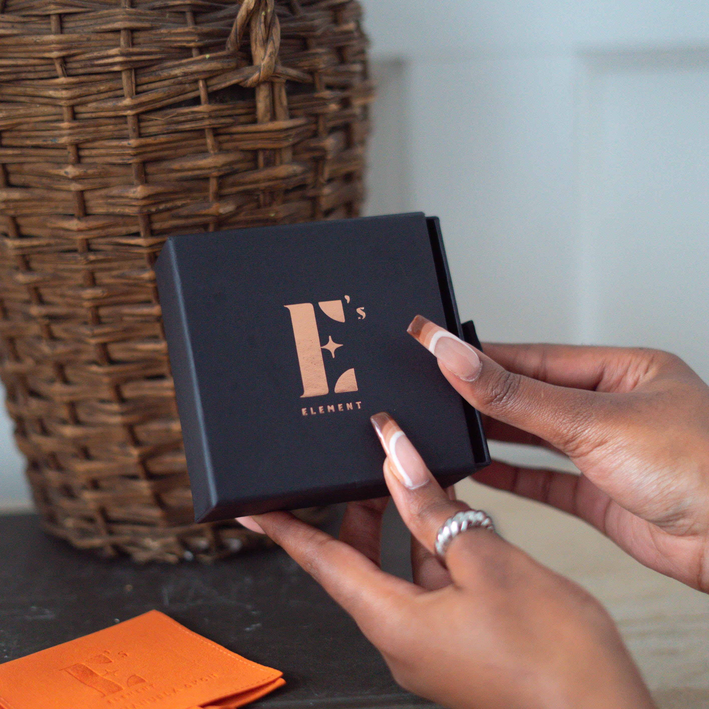 Hands holding an E's Element branded jewlery box