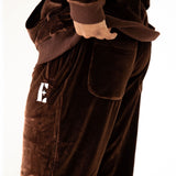 Model wearing dark brown velvet joggers. The joggers have the E's Element logo imprinted in white.