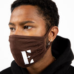 Man wearing E's Element reusable face mask in dark brown. The face mask is imprinted with the E's Element logo in white. Chocolate Face Mask by E's Element.