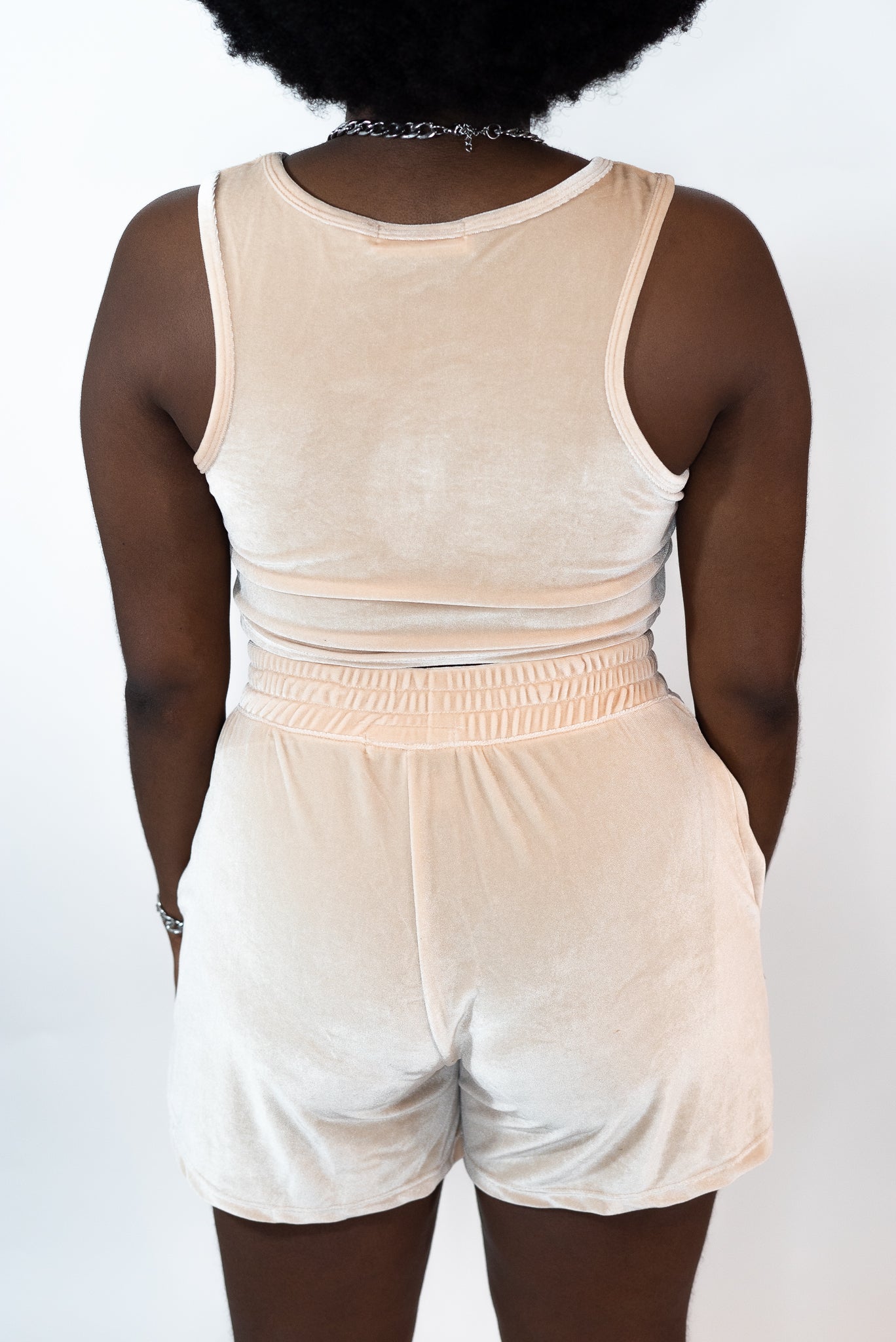 Back shot of model wearing beige tank top and shorts. The tank top has the E's Element logo imprinted in white in the middle. Ella Champagne Velvet Set by E's Element.Ella Champagne Velvet Set - E's Element