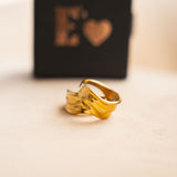 Two 18k gold molten rings stacked on each other. Behind the rings is the container for the rings. The container is black with the E's Element logo imprinted in gold. Ella Lava Ring 2.0 by E's Element.