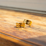 Two 18k gold molten rings placed on the edge of a window. Ella Lava Ring 2.0 by E's Element.