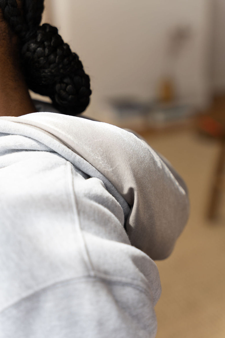 Woman wearing a light grey hoodie. The hoodie is a part of the Essential Light Grey Sweatsuit Set by E's Element.