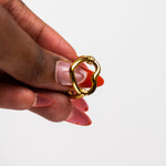 Model holding an 18k gold heart shaped ring. Ella's Element Hollow Heart Out Ring by E's Element.