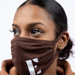 Woman in light brown hoodie wearing E's Element reusable face mask in brown. The face mask has E's Element logo imprinted in white. Build Your Own Reusable Masks by E's Element.