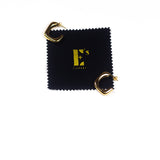 18k gold stainless steel hoop earrings resting on top of a polishing cloth with E's Element logo printed in gold. Angel Hoops by E's Element.