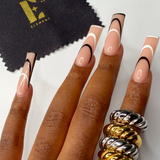 Four 18k gold and silver croissant shaped rings worn on the index finger. On the top left is a polishing cloth with the E's Element logo in yellow. Thick Croissant Rings by E's Element.
