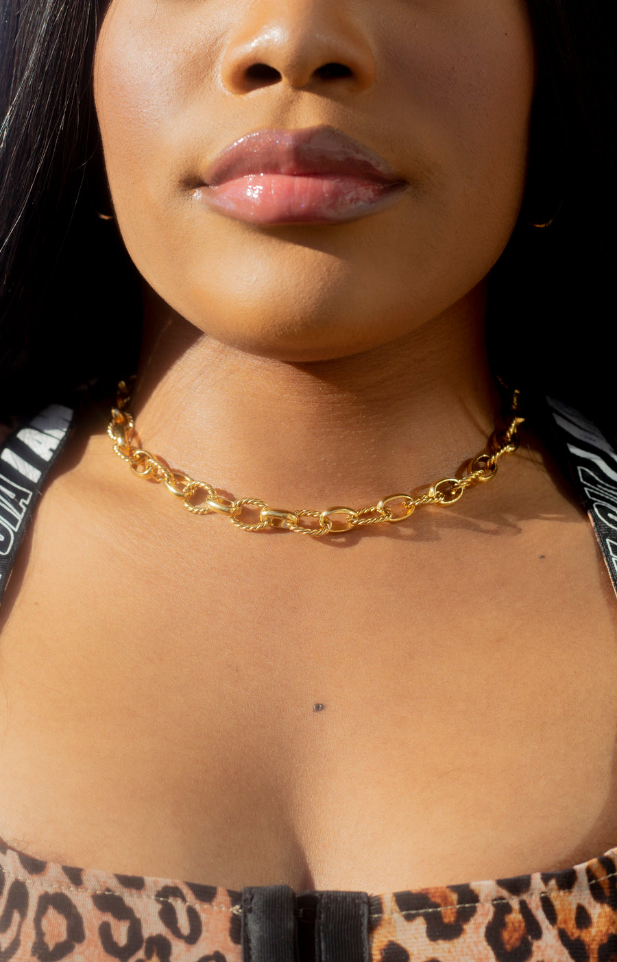 Model in a leopard top wearing 18k gold chain necklace with a rope pattern. Rope Link Signature Chain by E's Element.