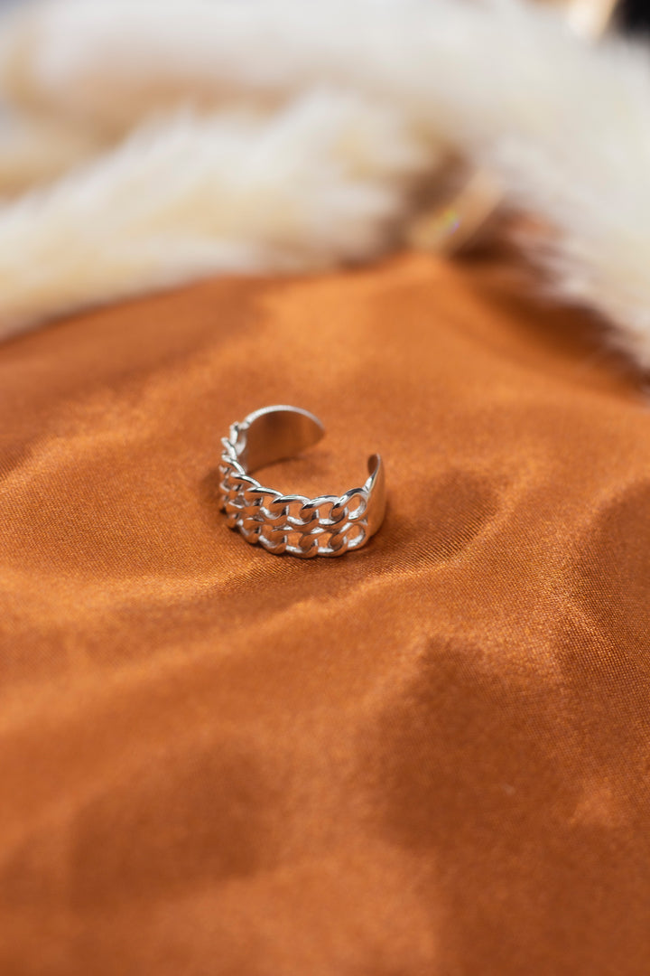 18k silver braided ring. The ring is placed on an orange cloth.  Platinum Double Band Ring by E's Element.