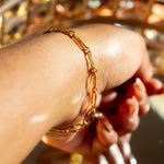 Model wearing 18k gold chain bracelet. Hollow Signature Chain Bracelet by E's Element by Emmanuela Okon