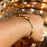 Model wearing 18k gold chain bracelet. Hollow Signature Chain Bracelet by E's Element by Emmanuela Okon.