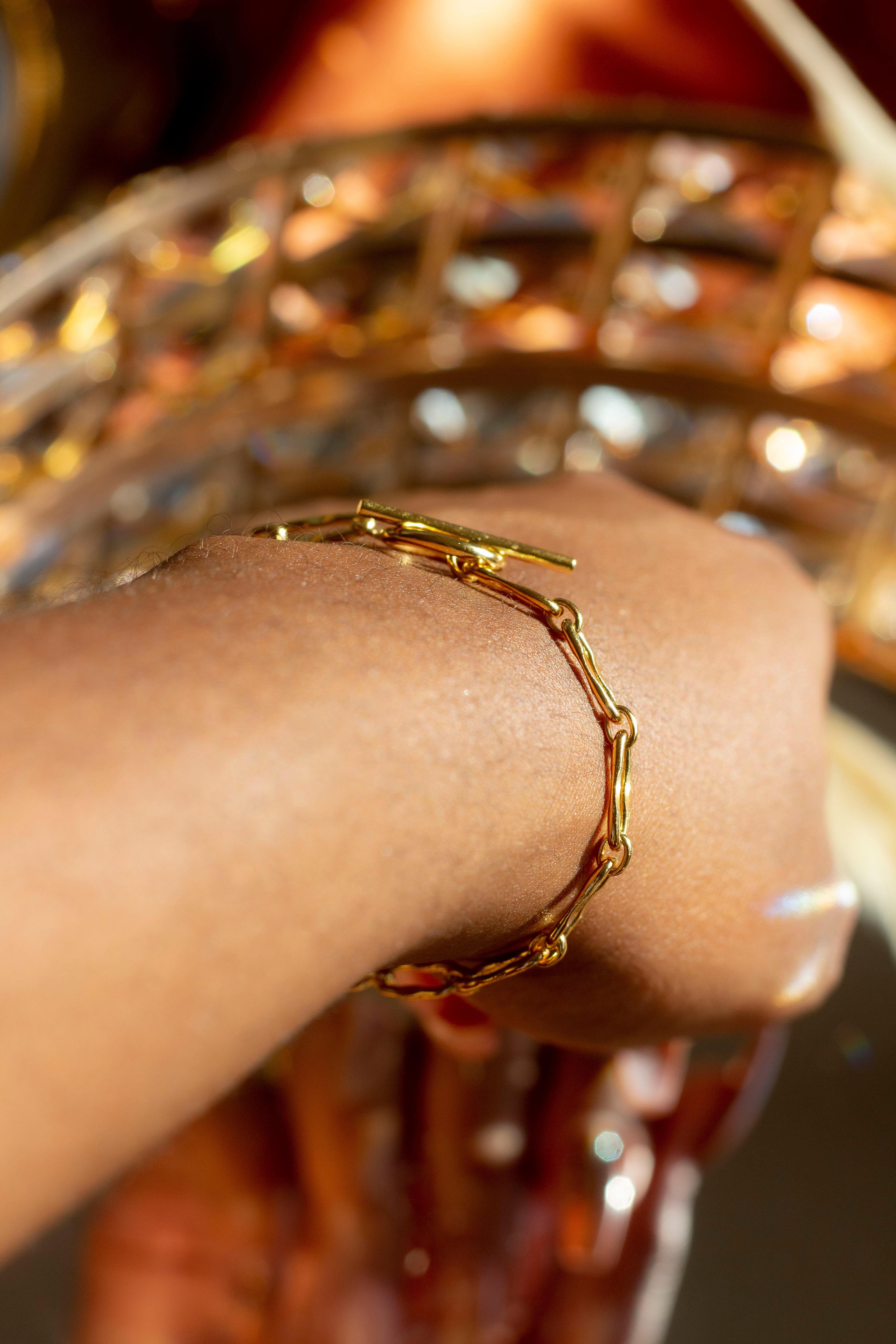 Model wearing 18k gold chain bracelet. Hollow Signature Chain Bracelet by E's Element by Emmanuela Okon.