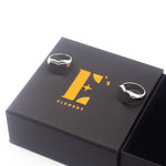 Two 18k silver heart signet rings resting on a black box with the E's Element logo imprinted in yellow. Ellina Heart Signet Ring by E's Element.