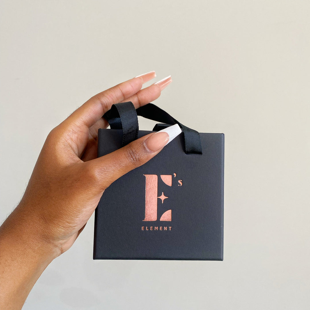 Model holding a black gift box with the E's Element logo in gold. Gift Box With Handle - E's Element