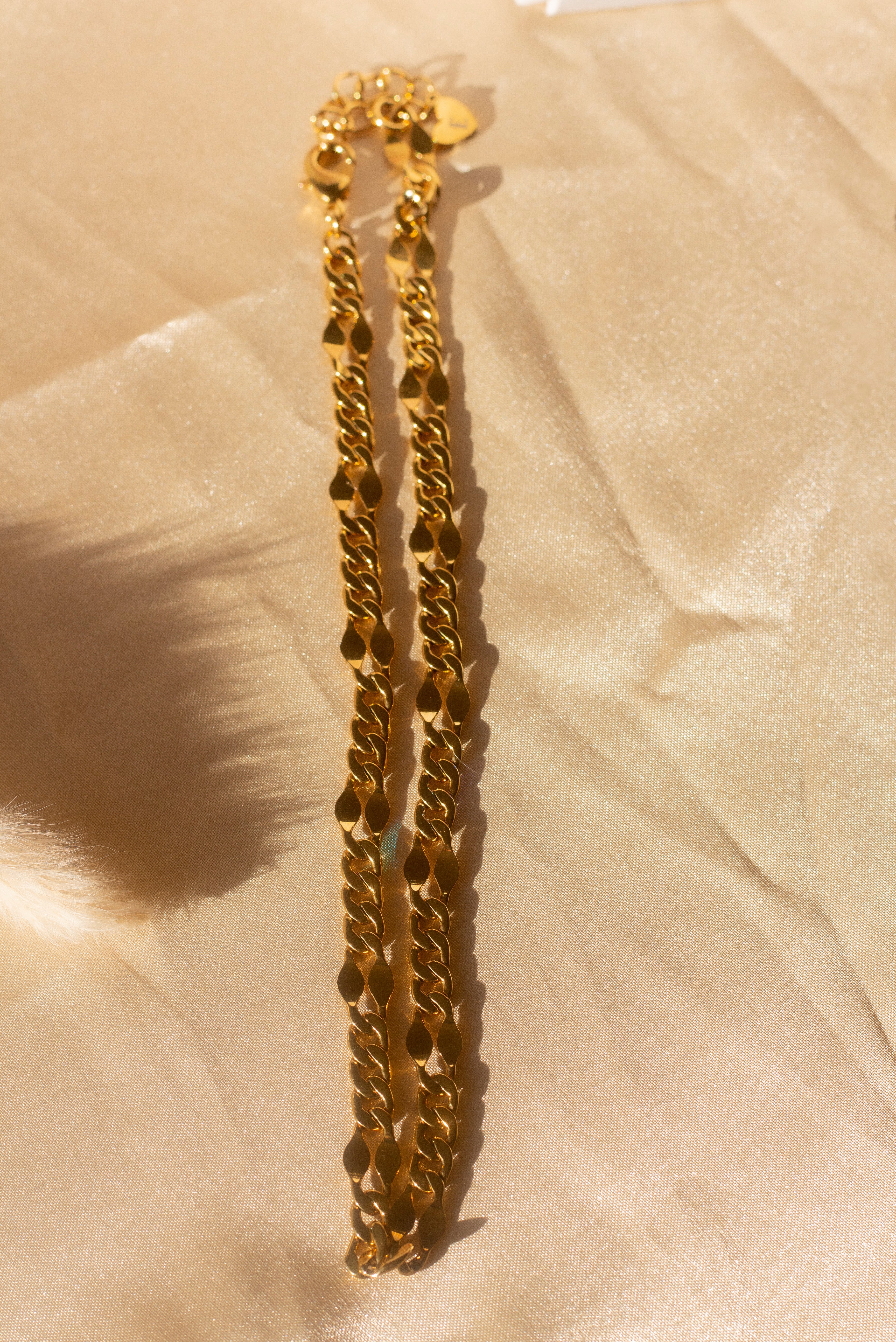 18k gold chain necklace placed on a beige cloth. Ella Figaro Necklace by E's Element.