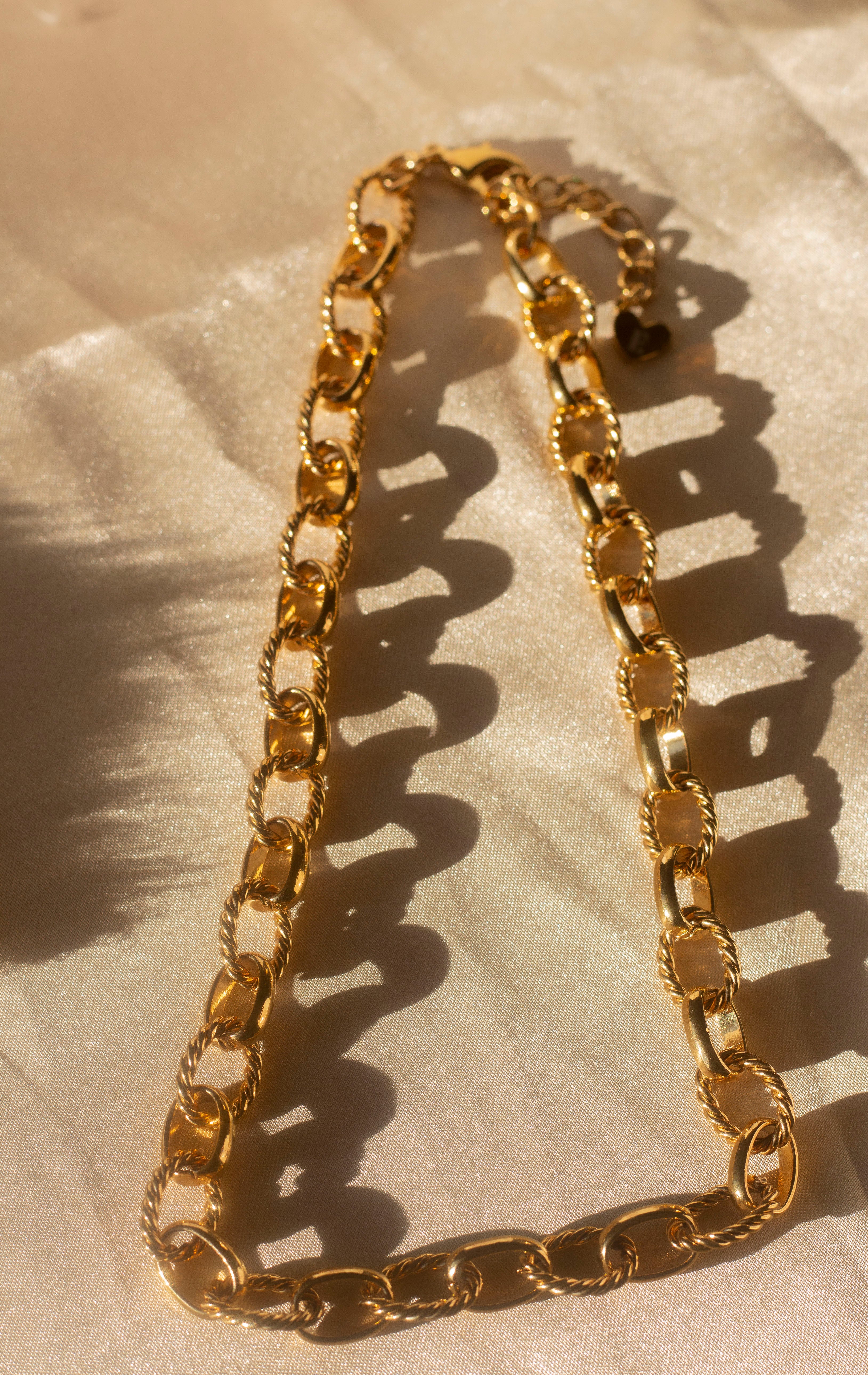 18k gold chain necklace with a rope pattern. The chain is placed on a beige cloth. Rope Link Signature Chain by E's Element.