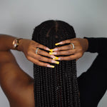 Back shot of a model in a black top wearing 18k gold ring with white baguettes. The model is also wearing a watch. Ella Tennis Ring by E's Element.