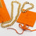 18k gold chain necklace in the middle. On the right is an 18k gold chain bracelet placed on an orange leather pouch. The Emmanuela Set in Gold by E's Element.