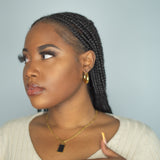 Woman in beige top wearing 18K gold stainless steel hoop earrings. Named Alyssa Hoops by E's Element.