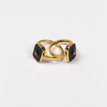 Two 18k gold rings. The rings have a zircon stone in the middle of a rectangular black surface. Infinity Zircon Ring by E's Element.