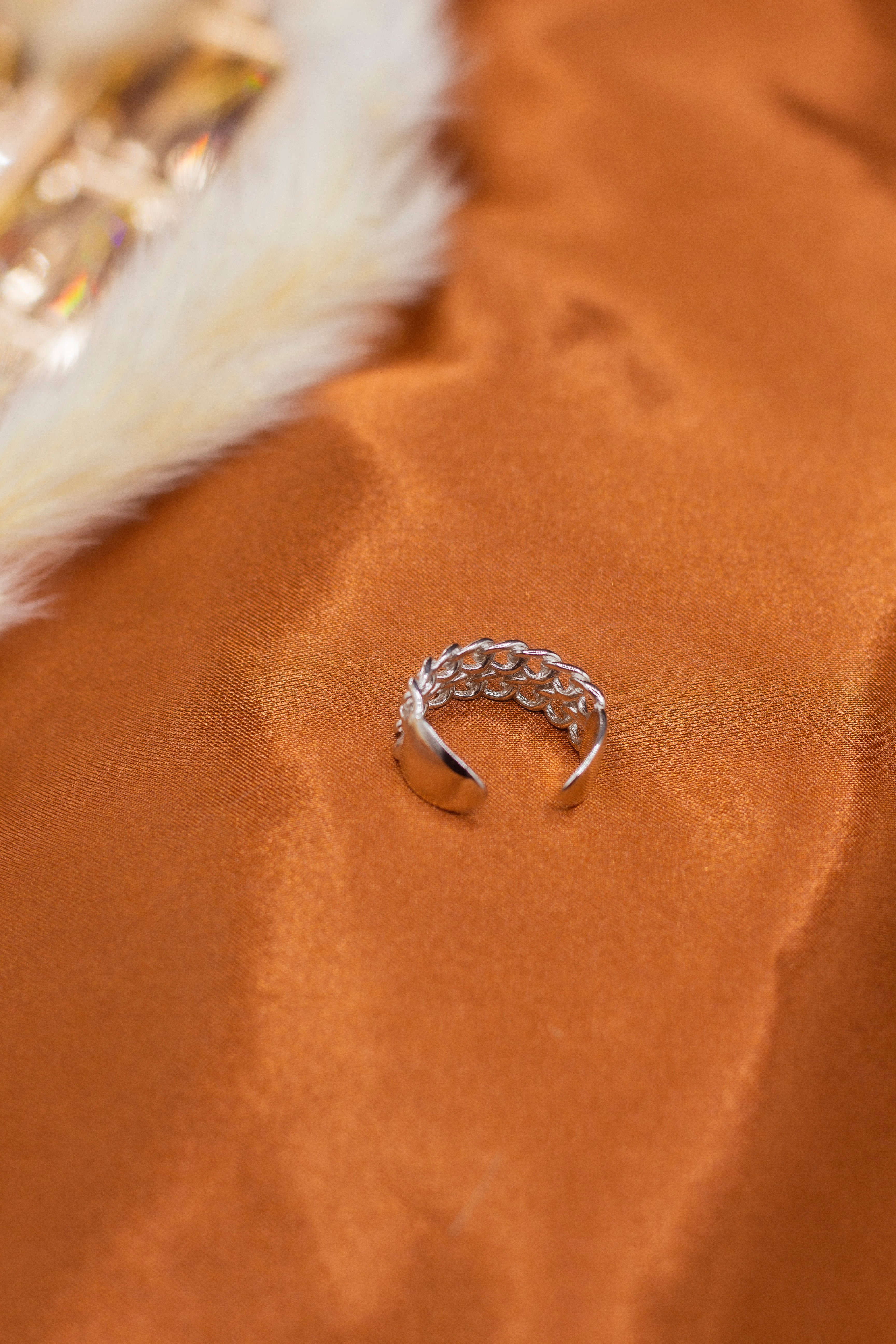18k silver braided ring resting on an orange cloth. Platinum Double Band Ring by E's Element.