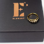 18k gold ring with black and white diamond dots. The ring is placed on a black container with E's Element logo imprinted in gold. Minimalist Resin Ring by E's Element.