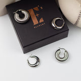 Two pairs of stainless steel earrings resting on their container. Build Your Own Earring Set by E's Element.