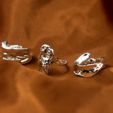 18k silver molten rings place side-by-side on an orange cloth. Ella Lava Ring Trio (Set of 3) by E's Element.
