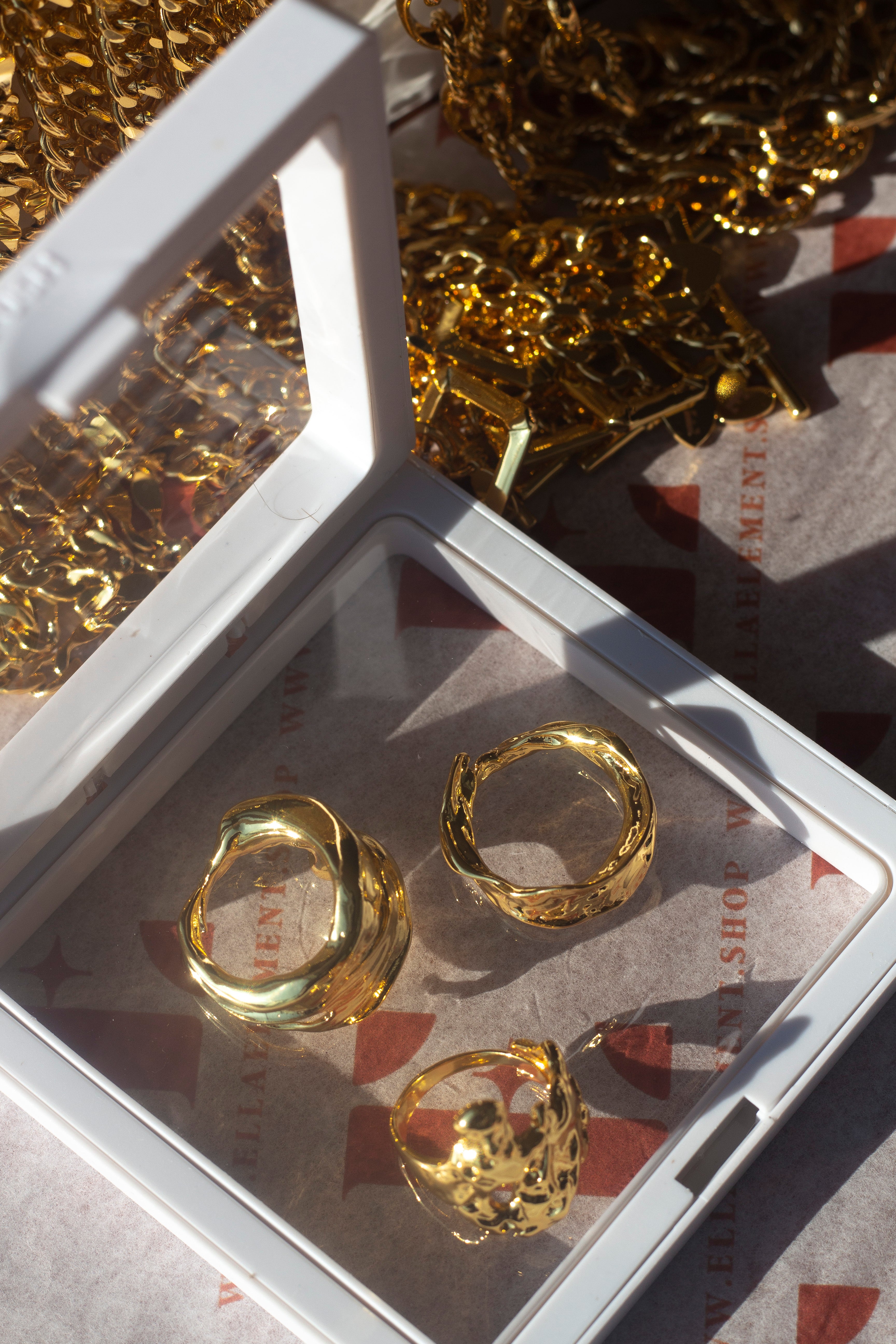 Three 18k gold molten rings placed on a glass table. Ella Lava Ring Trio (Set of 3) by E's Element.